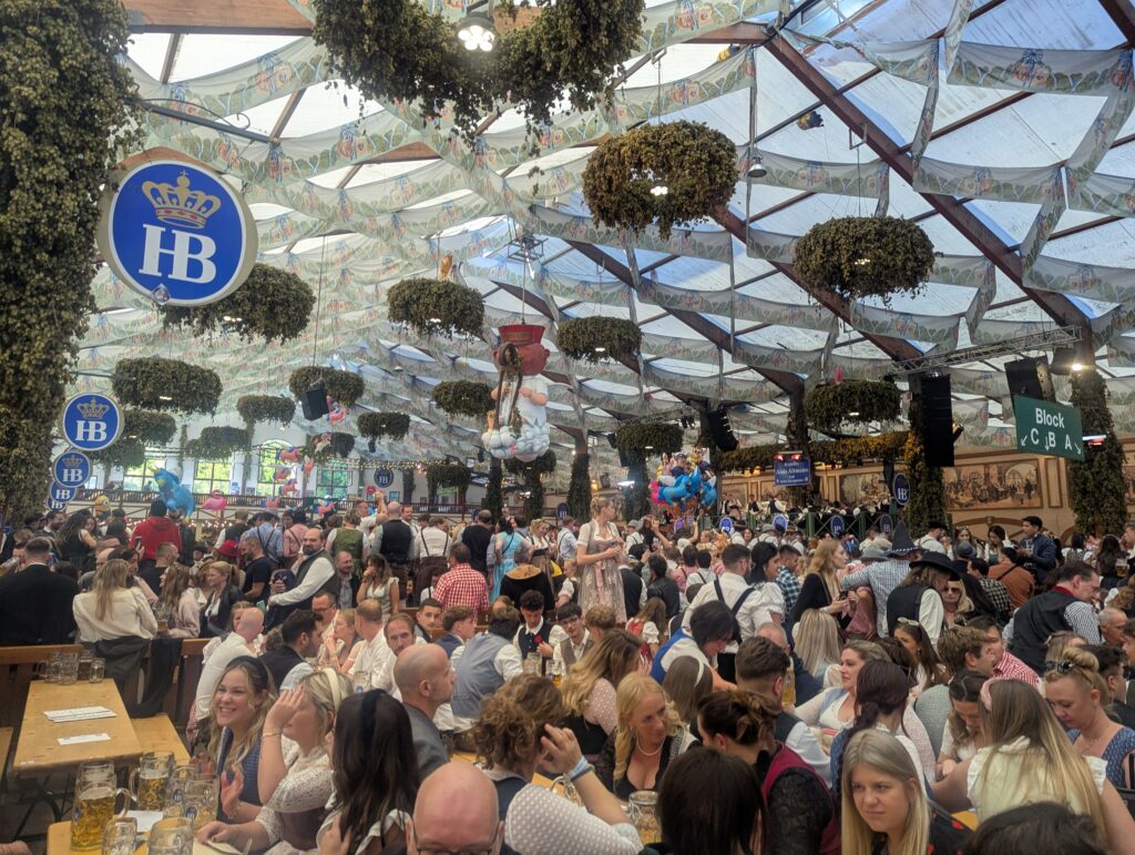 Bright daytime atmosphere inside a packed Oktoberfest beer tent