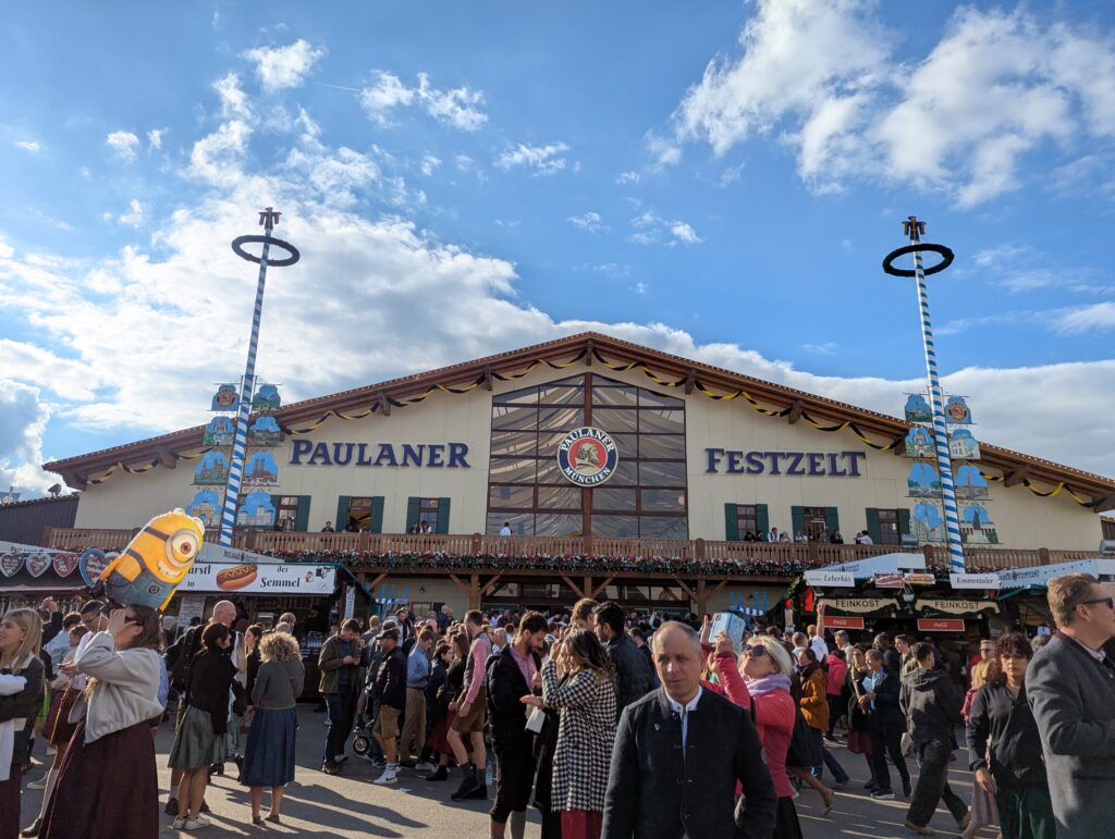 Paulaner Festzelt exterior with crowds of visitors on a sunny Oktoberfest afternoon