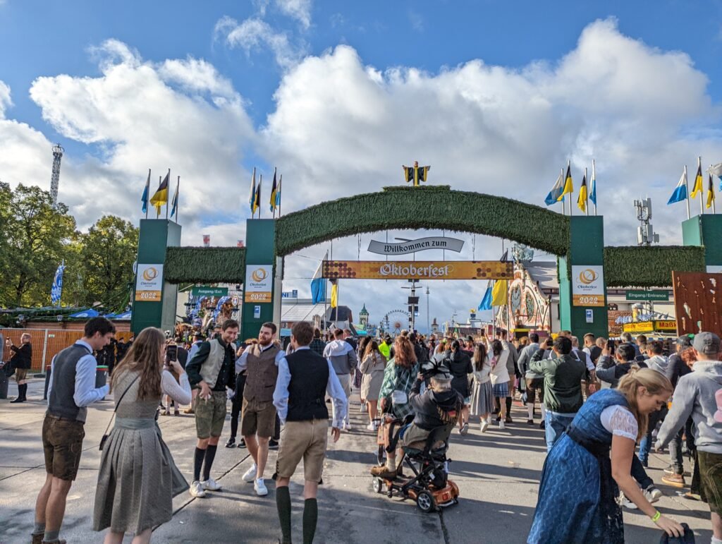 Visitors in full Bavarian tracht outfits at the Oktoberfest welcome arch