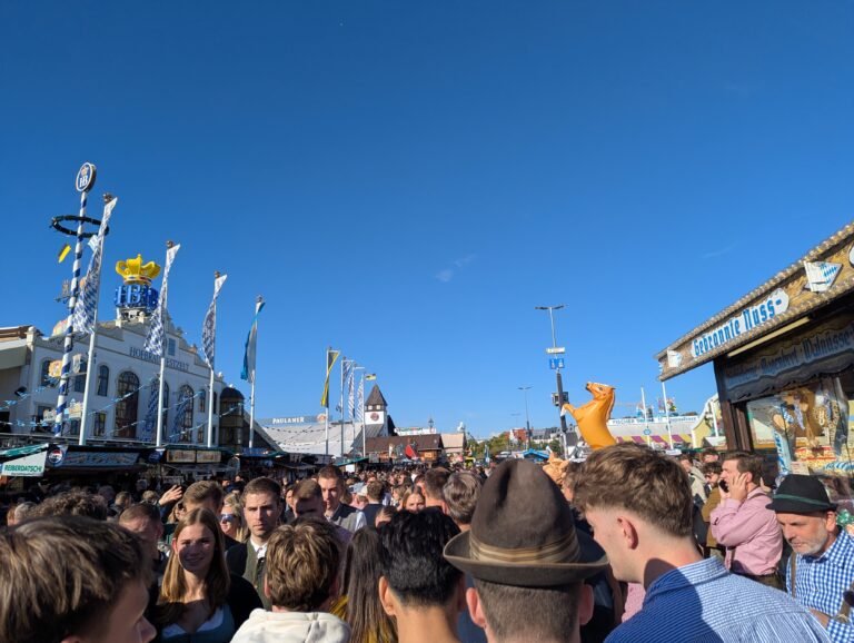 Packed central avenue at Oktoberfest with the Hofbrau tent and blue sky
